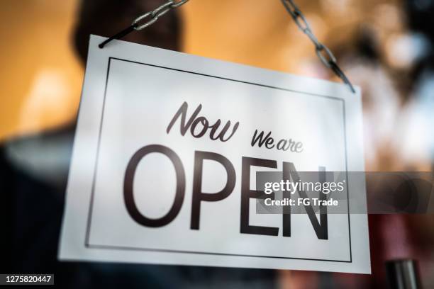 opened sign seen through glass door at store - store opening covid stock pictures, royalty-free photos & images