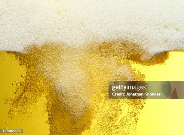 close up frothy beer bubbles - bier stockfoto's en -beelden