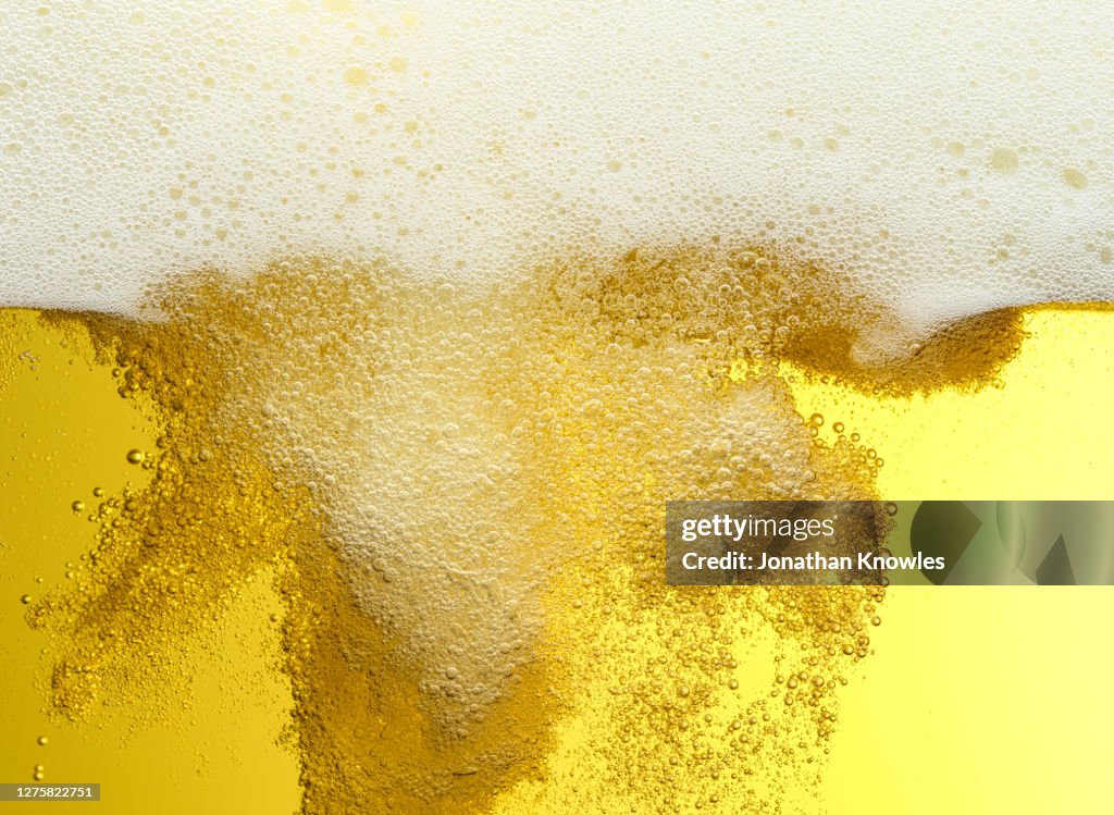 Close up frothy beer bubbles