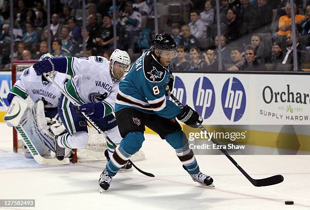 Joe Pavelski of the San Jose Sharks keeps the puck away from Ryan Parent of the Vancouver Canucks at HP Pavilion on September 29, 2011 in San Jose,...