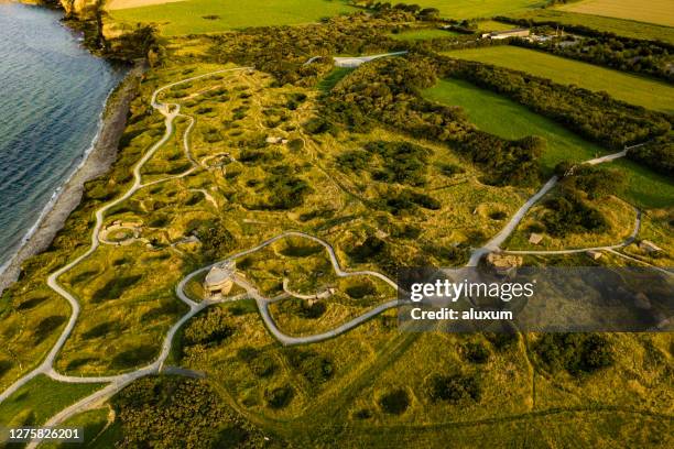 le point du hoc is the top of a cliff that was taken at the beggining of the d day invasion by the allies troops by climbing the cliffs nowadays it is a memorial left as it was with bunkers and bomb craters seen from the air. - 1944 stock pictures, royalty-free photos & images