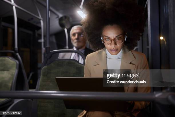 afroamerikanische geschäftsfrau arbeitet auf laptop tragen kopfhörer auf bus - laptop on bus stock-fotos und bilder