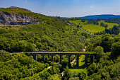 Aerial drone view of a Victorian era viaduct in a beautiful green valley (Pontsarn Viaduct, Brecon Beacons, Wales)