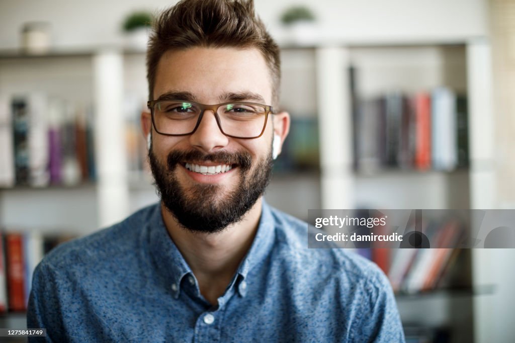 Smiling young man having online conference from home