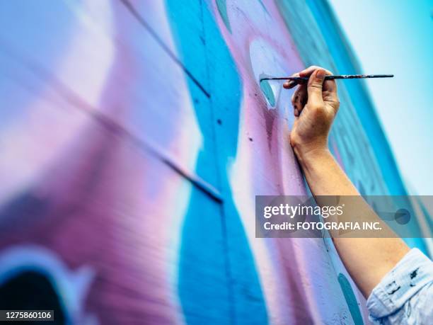main de l’artiste féminin de peinture murale au travail - peinture murale photos et images de collection