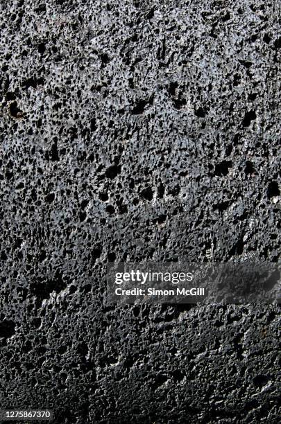 surface of a volcanic grinding stone - vulkanisch gesteente stockfoto's en -beelden