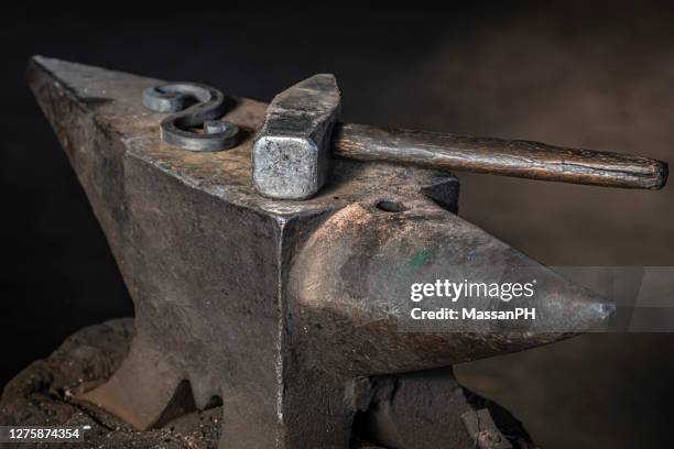 anvil and hammer in an old dusty blacksmith's workshop - metal hammer stock pictures, royalty-free photos & images