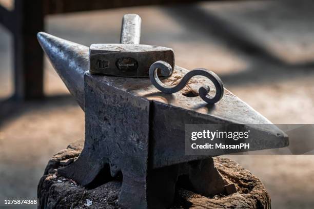 anvil and hammer in an old dusty blacksmith's workshop - amboss stock-fotos und bilder