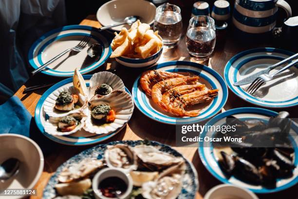 fresh seafood served on the dining table in restaurant - vis en zeevruchten stockfoto's en -beelden