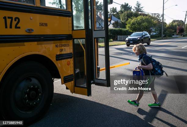 Second grader Wright Malloy boards a school bus bound for Rogers International School on September 23, 2020 in Stamford, Connecticut. Most students...