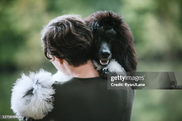 young woman spending quality time with her dog outside - standard poodle stock pictures, royalty-free photos & images