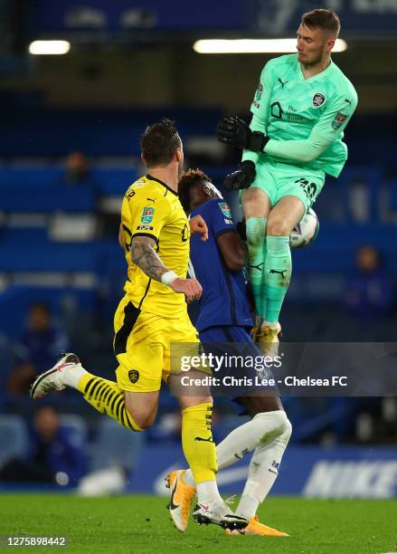 Tammy Abraham of Chelsea clashes with Brad Collins of Barnsley during the Carabao Cup third round match between Chelsea and Barnsley at Stamford...