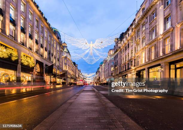 christmas light decorations on regent street at dusk, london, uk. - regent street stock pictures, royalty-free photos & images