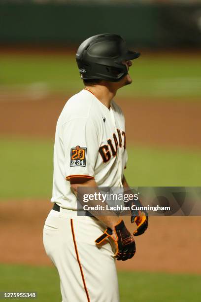 Alex Dickerson of the San Francisco Giants grimaces after being hit by a pitch in the bottom of the ninth inning against the Colorado Rockies at...