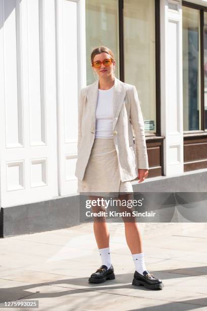 Co-Founder of Rotaro Georgie Hyatt wears Gucci shoes, Nike socks, Topshop top, Han Kjobenhavn sunglasses and a Jillian Boustred suit during LFW...