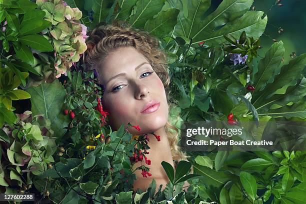 young beautiful woman lying on a bed of leaves - art modeling studio stock-fotos und bilder