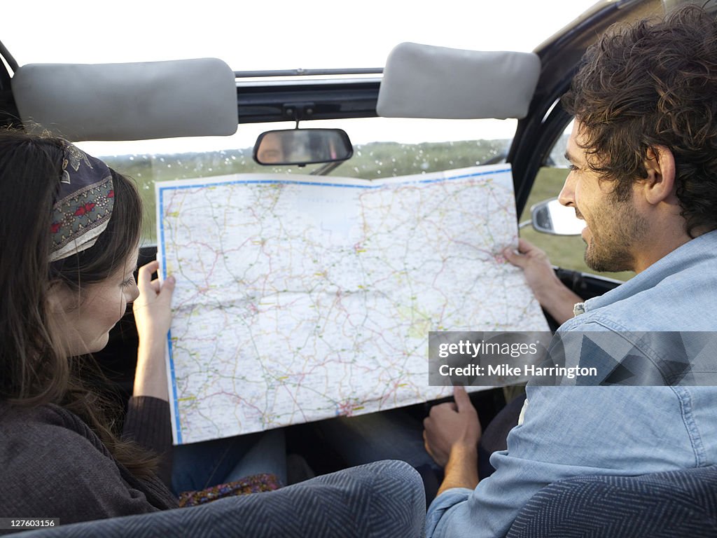 Man and lady in car looking at map