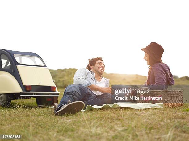 young couple with picnic basket - twilight picnic stock pictures, royalty-free photos & images