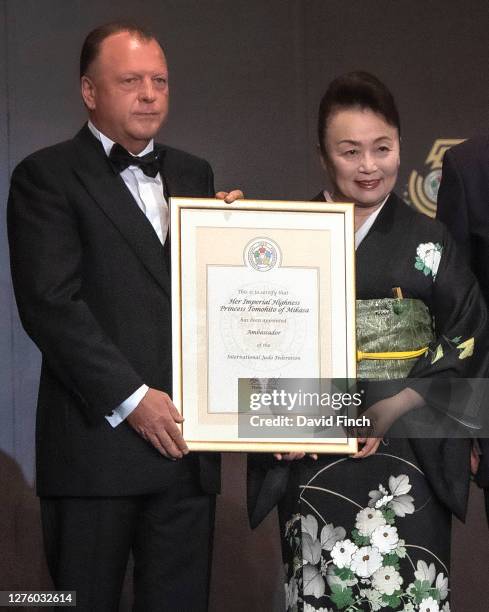 The President of the International Judo Federation, Marius Vizer hands a certificate to Princess Tomohito of Mikasa certifying that she has been...