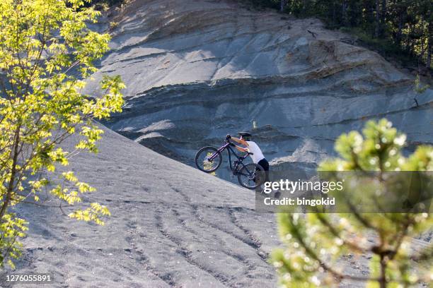 man pushing bike uphill - uphill stock pictures, royalty-free photos & images