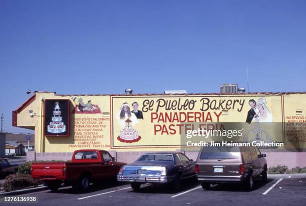 El Pueblo Bakery in South Gate, California has images of a wedding cake, bride, and groom painted on the side of the building, circa 1995.