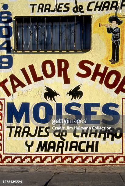 Moises Tailor Shop in Los Angeles, California has a busy but festive facade with a lot of words squeezed into a tight area, 2000.
