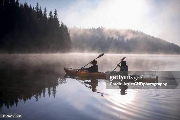 junge und mädchen reisen mit ihrem kajakboot in den bergen - kayak stock-fotos und bilder