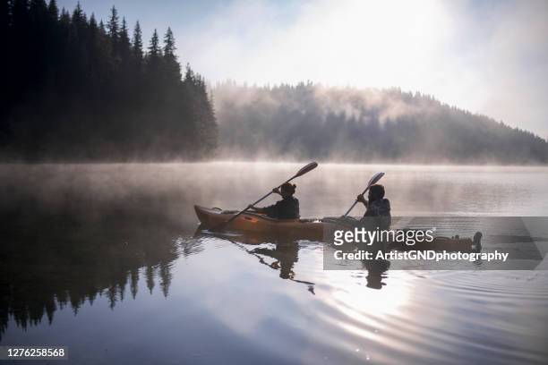 boy and girl are travelling with their kayak boat at mountains - kayak stock pictures, royalty-free photos & images