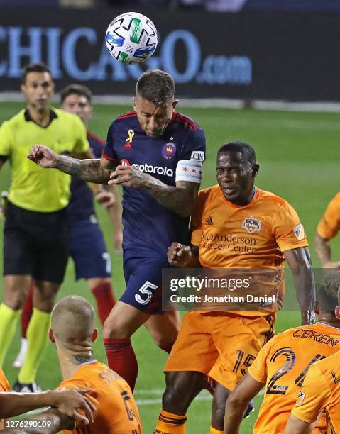 Francisco Calvo of Chicago Fire FC heads the ball over Maynor Figueroa of Houston Dynamo on a corner kick at Soldier Field on September 23, 2020 in...