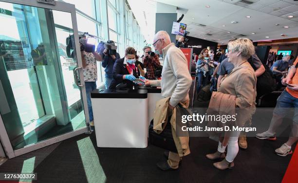 Qantas crew check passengers onboard a Qantas Boeing 737-800, flight number QF735 from Sydney to Adelaide at Sydney Airport on September 24, 2020 in...