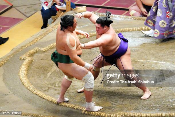 Meisei pushes Sadanoumi out of the ring to win on day eleven of the Grand Sumo Autumn Tournament at Ryogoku Kokugikan on September 23, 2020 in Tokyo,...