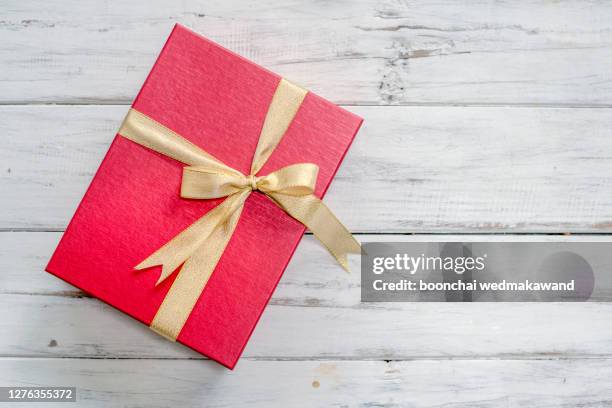 gift box with red bow ribbon and paper heart on wooden table for valentines day - build presents suits stockfoto's en -beelden