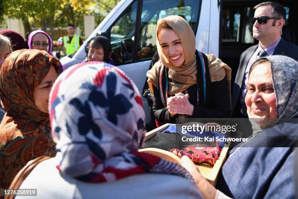 New Zealand Prime Minister Jacinda Ardern receives a scarf from members of the Muslim community before she unveils a plaque at Al Noor Mosque on...