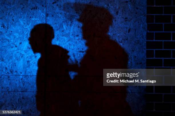 The shadow of a Louisville Police officers arresting a demonstrator is seen on a wall on September 23, 2020 in Louisville, Kentucky. A Kentucky grand...