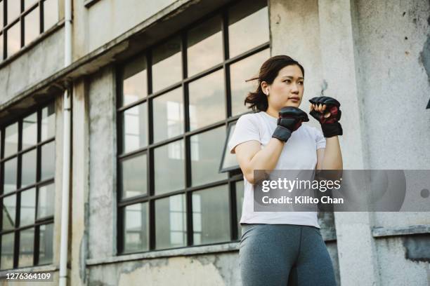 asian woman practicing boxing outdoor - self defence stock-fotos und bilder