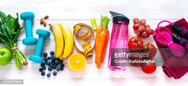 exercising and healthy food: raibow colored fruits, vegetables and fitness items - healthy lifestyle stock pictures, royalty-free photos & images