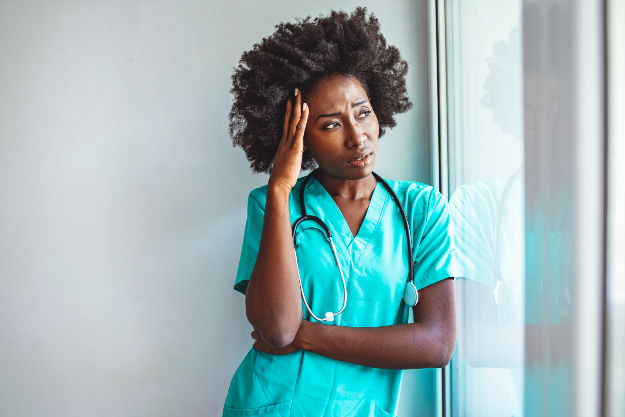Tired female nurse in hospital corridor. Tired female nurse in hospital corridor.