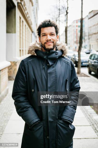 portrait of man wearing parka - winterjacke stock-fotos und bilder