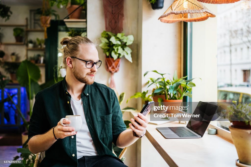 Student Using Smartphone While Drinking Coffee
