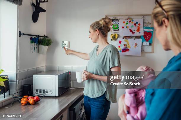 adjusting the thermostat - electricity meter stock pictures, royalty-free photos & images