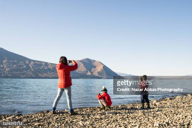 Mother taking photo of kids at Lake.