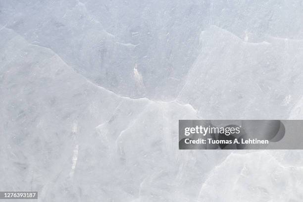 close-up of cracked ice on a frozen lake in the winter, viewed from above. - ice texture foto e immagini stock