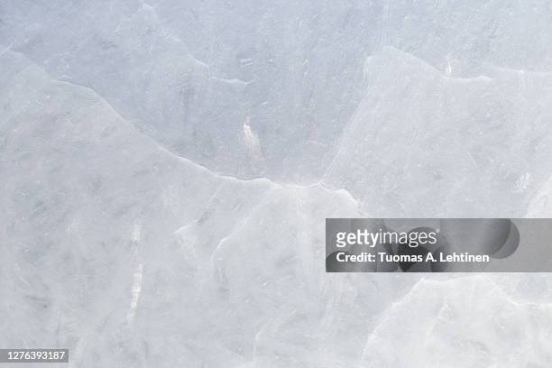 close-up of cracked ice on a frozen lake in the winter, viewed from above. - ice stockfoto's en -beelden