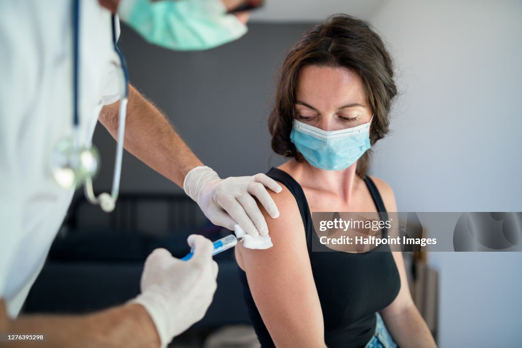 Woman with face mask getting vaccinated, coronavirus concept.