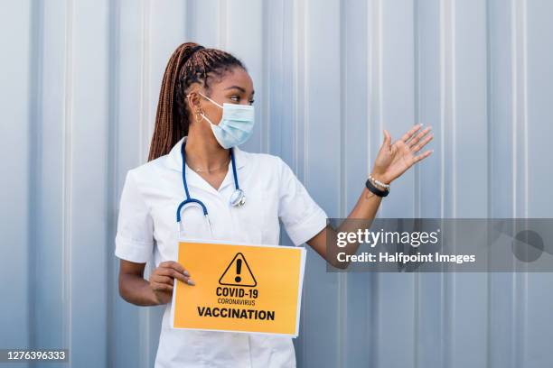 young doctor holding covid-19 vaccination sign, coronavirus concept. - slovakia vaccine stock pictures, royalty-free photos & images