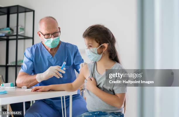 small child with face mask getting vaccinated, coronavirus concept. - slovakia vaccine stock pictures, royalty-free photos & images