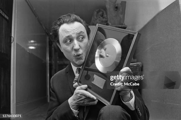 English comedian Ken Dodd with a golden disc for his hit single 'Tears', December 1965.