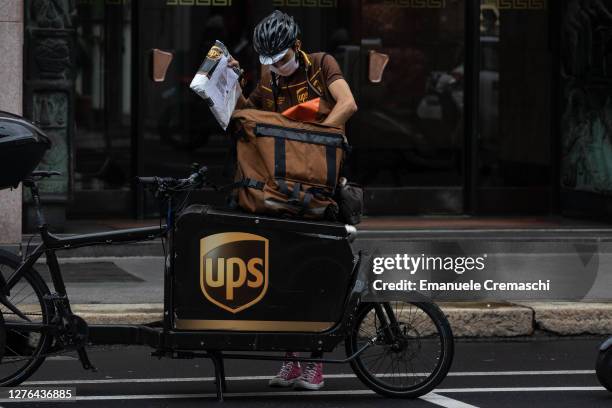 Delivery man for United Parcel Service handles a parcel next to his cargo bike on September 23, 2020 in Milan, Italy. Since the end of lockdown Milan...