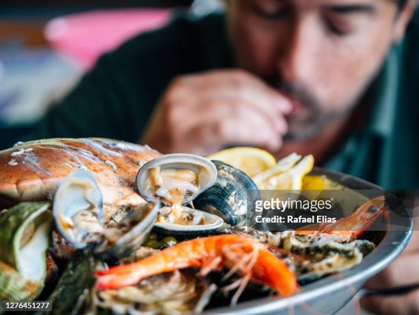 man eating seafood - clams cooked stock-fotos und bilder