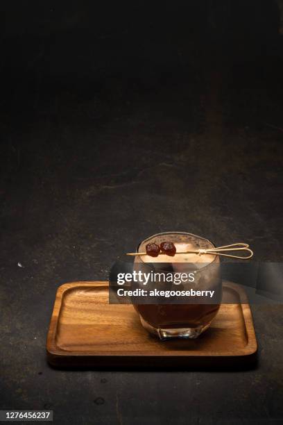 glass of tasty iced coffee on table - espresso martini stock-fotos und bilder